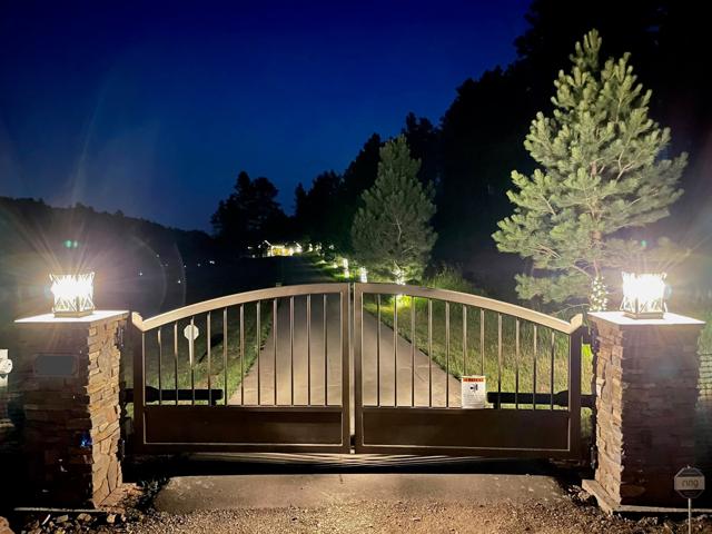 Automated driveway gate lit at night