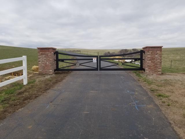 Cross-braced double gate on brick pillars