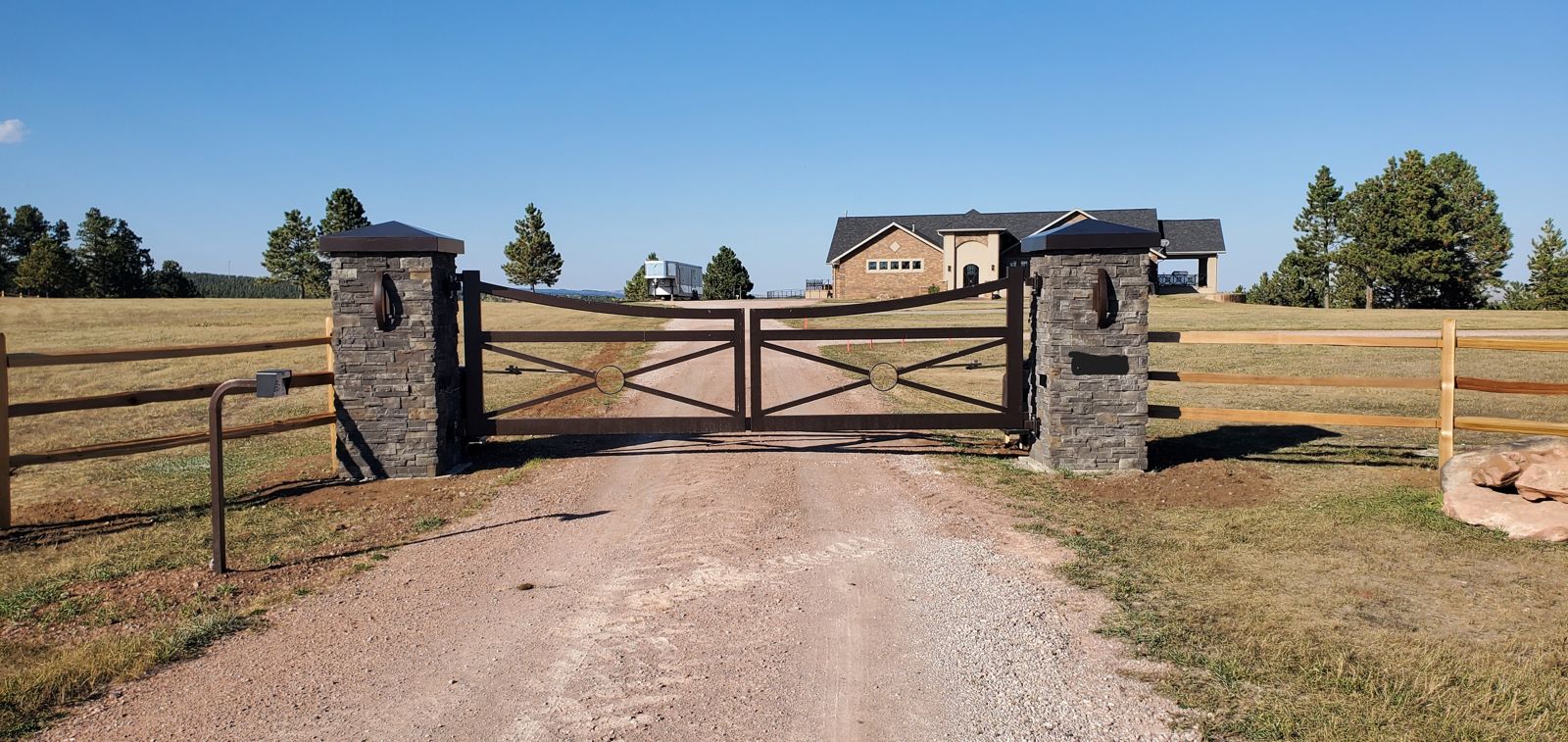 Ranch gate hung on stone masonry columns