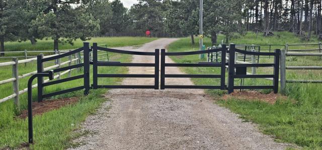 Black rail ranch gate on a country drive