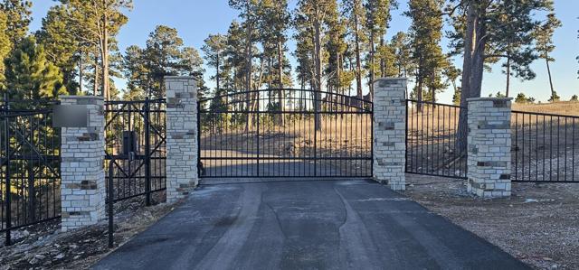 Ornamental estate gate with stone pillars and matching fence