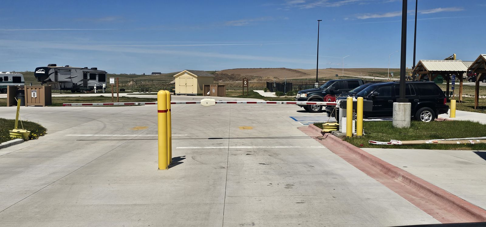 Steel bollards and barrier arm protecting a commercial entrance lane