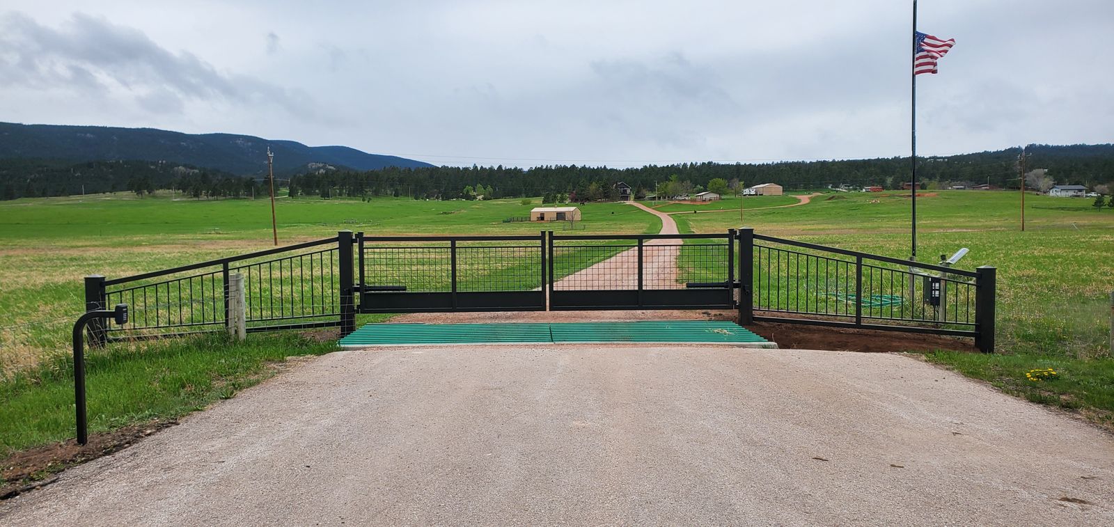 Custom slide gate with matching rail fence and cattle guard in the Black Hills