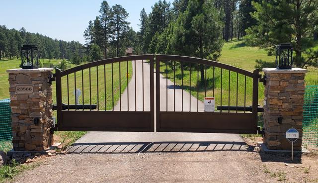 Arched driveway gate with stone pillars
