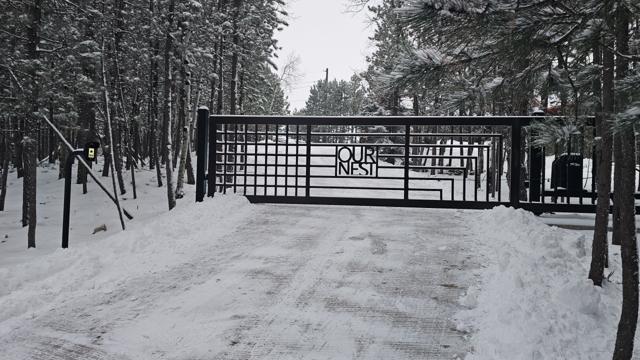 Slide gate with custom OUR NEST lettering in winter